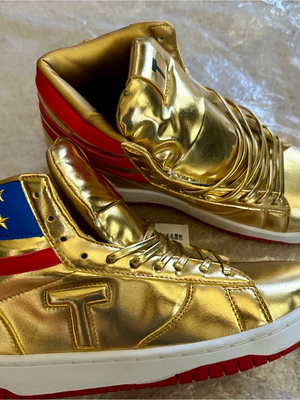 Never Surrender in Gold High-Top Sneakers with Red & Blue Accents